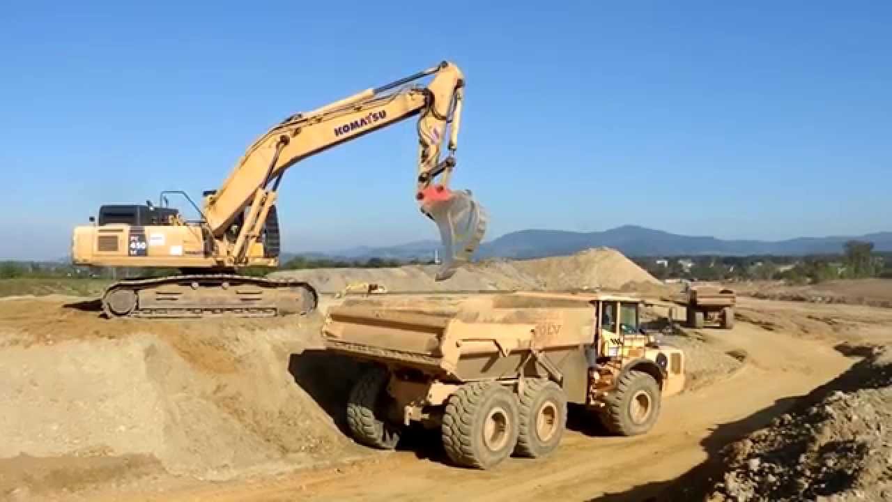 Crane pouring dirt into dump truck